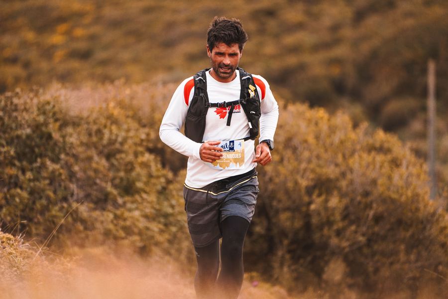Coureur de trail en pleine course, sentier en sous-bois